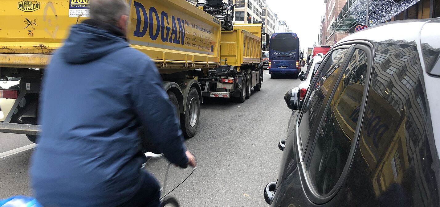 Enge im Straßenverkehr ohne separaten Radweg Man fährtzwischen LKW und parkenden Autos Rad